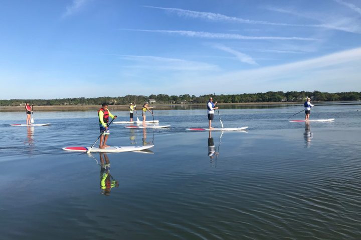 a group of people riding skis on a body of water